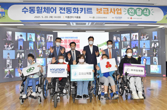 현대그룹 임원 등이 전동화키트를 전달받은 장애인 5명과 기념사진을 찍고 있다.        <현대차 제공>